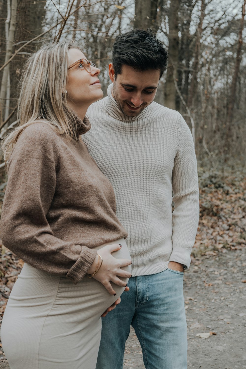 a man and a woman standing next to each other in the woods