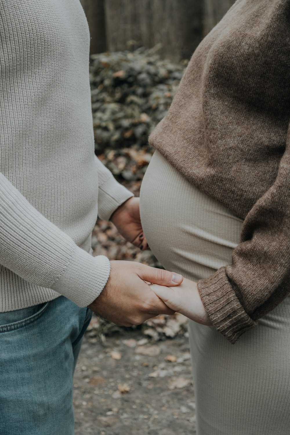 a pregnant woman holding the belly of a man