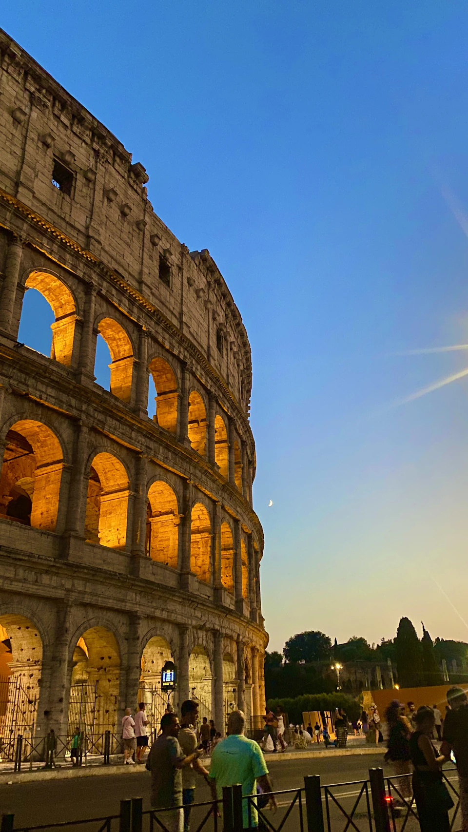 Visitors at the Colosseum during a warm Roman summer evening with golden light on the ancient walls