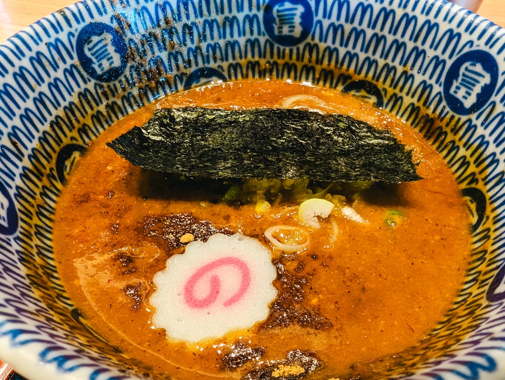a bowl of soup with a piece of sushi on top of it