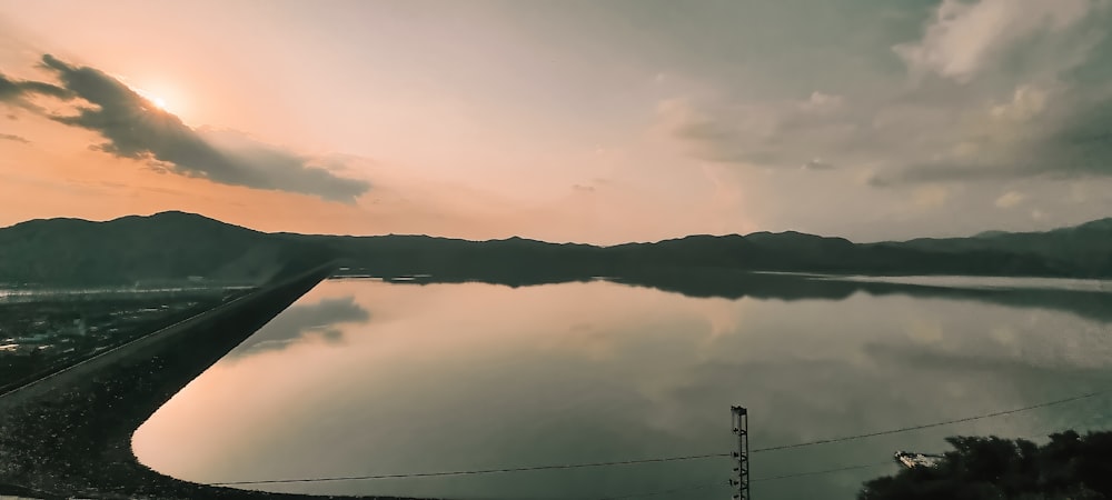 a large body of water sitting under a cloudy sky