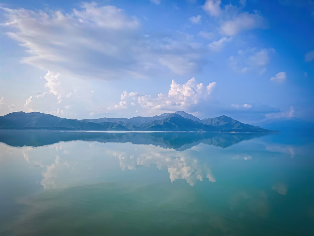 a large body of water with mountains in the background