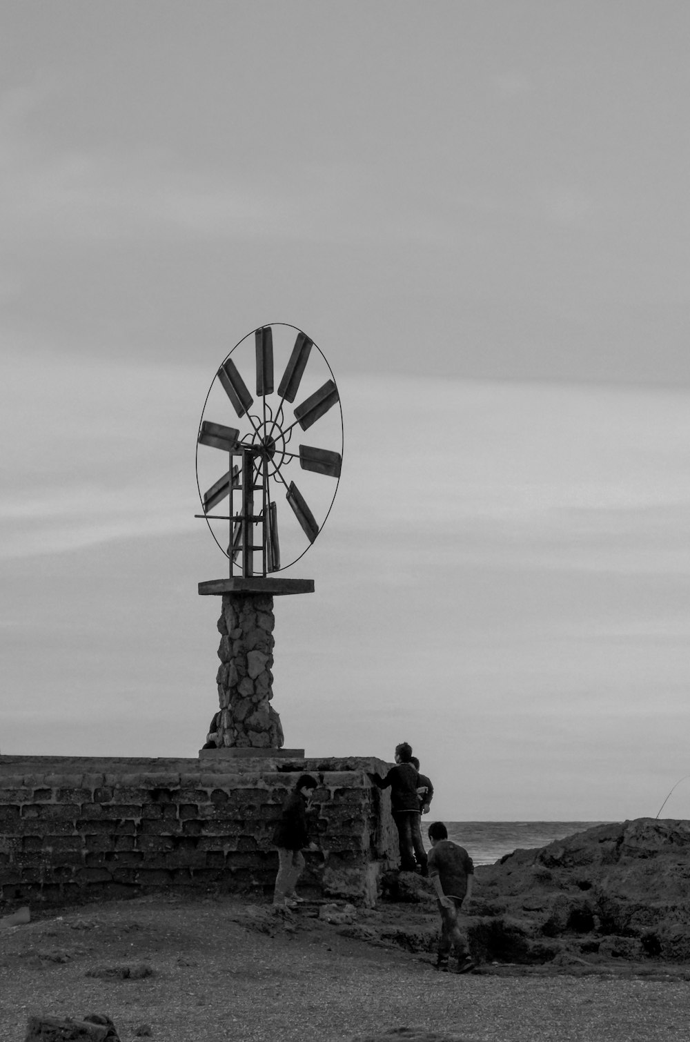 a man standing next to a windmill on top of a field