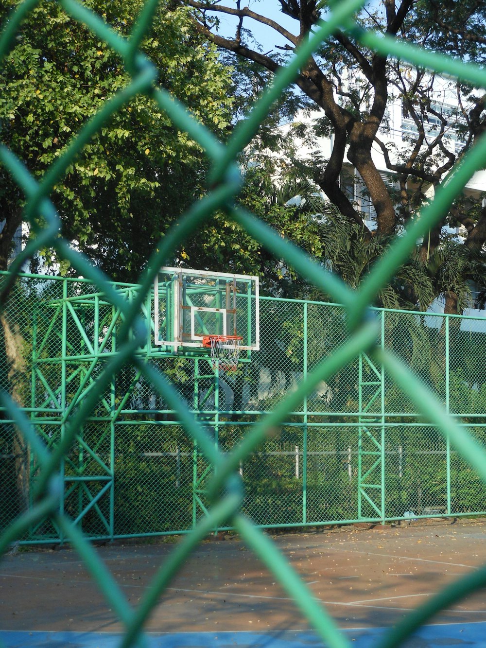 a basketball court through a chain link fence