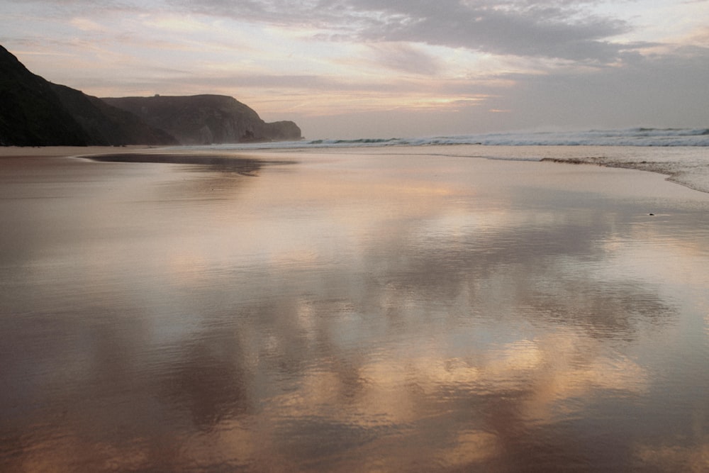 a sandy beach with waves coming in to shore