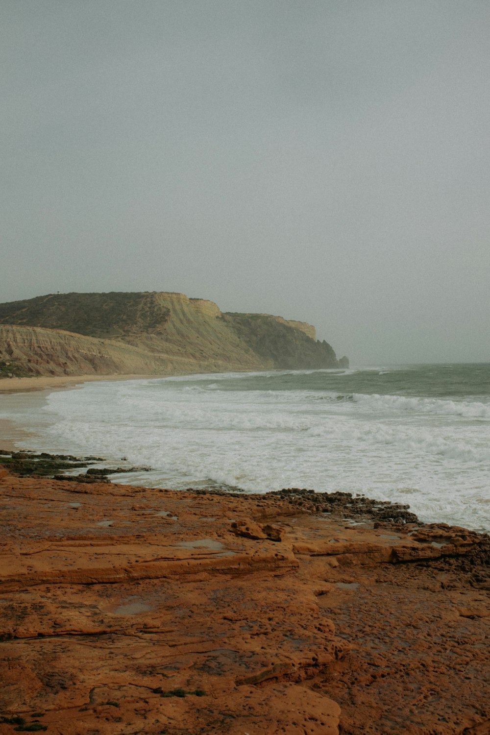 a person standing on a beach with a surfboard