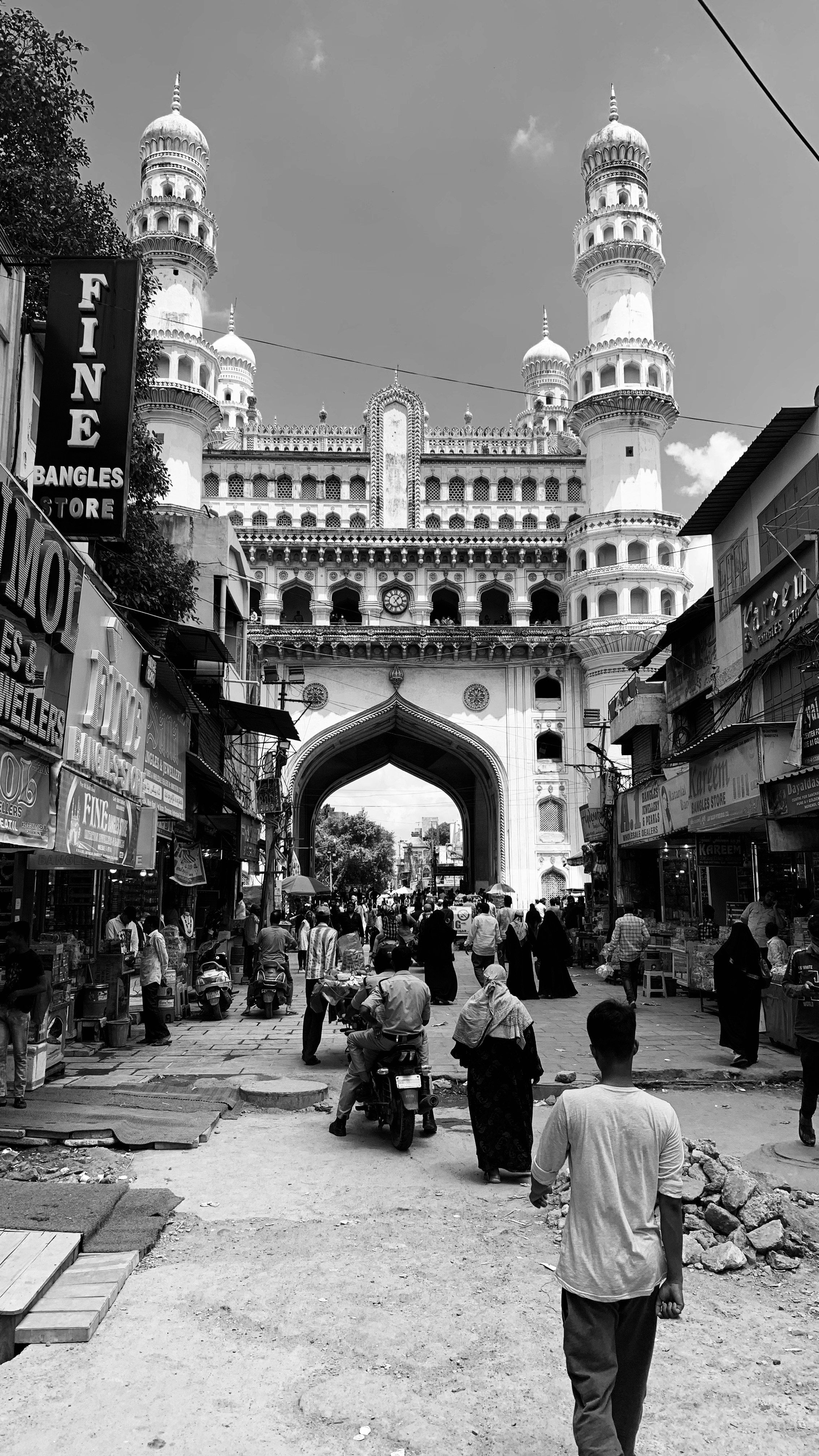 a black and white photo of people walking in front of a building