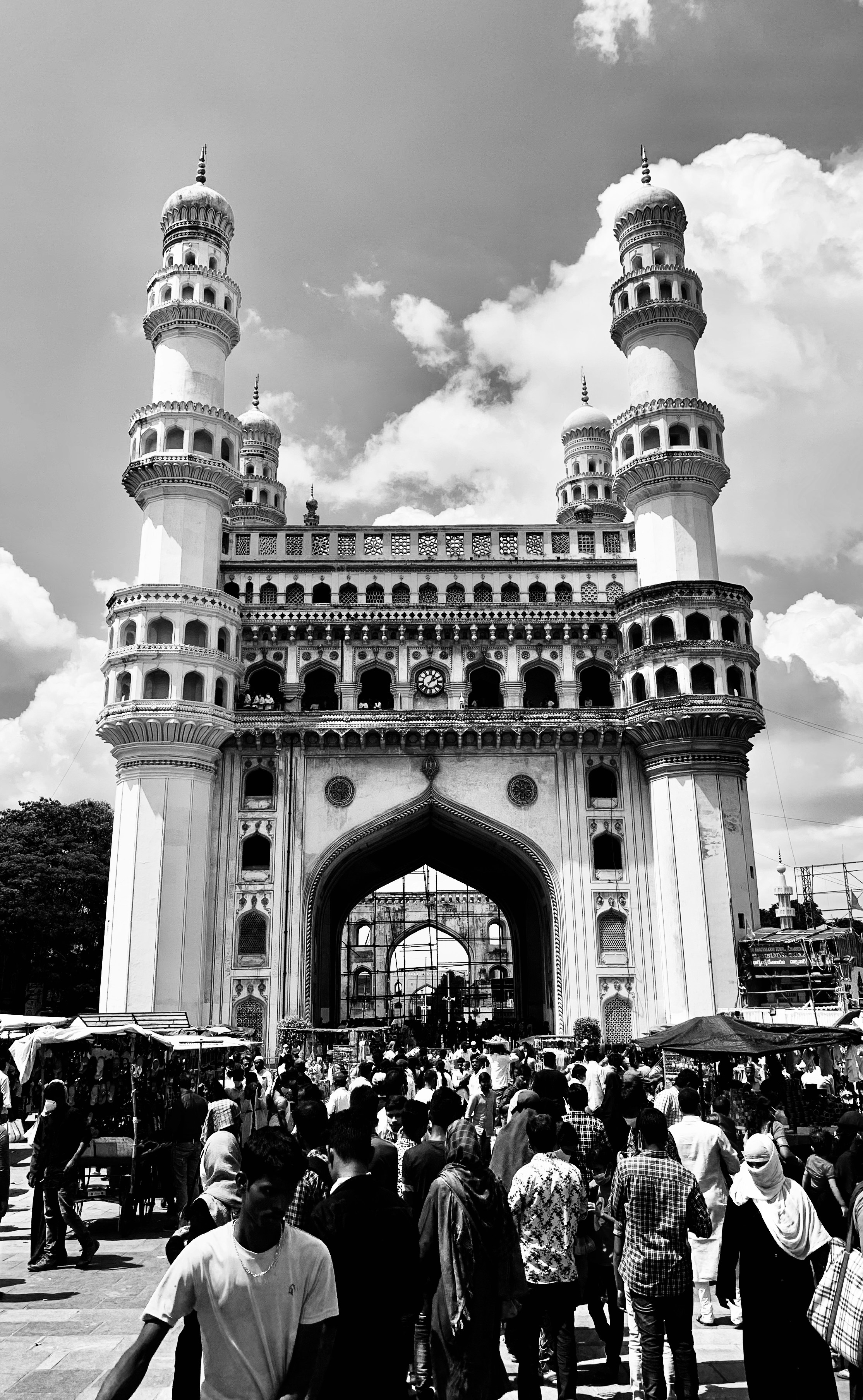 a black and white photo of people walking in front of a building