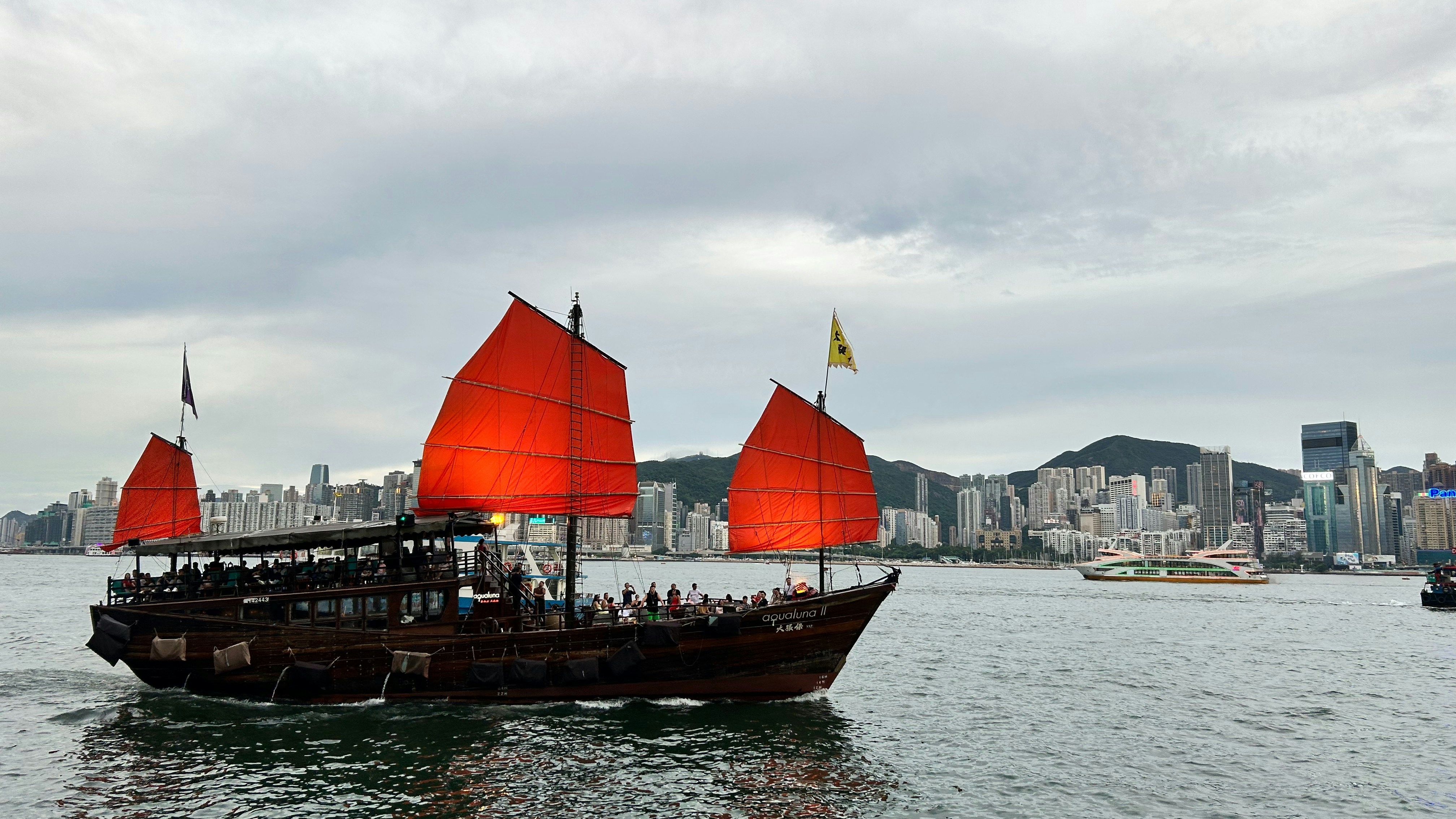 a boat with red sails in a body of water