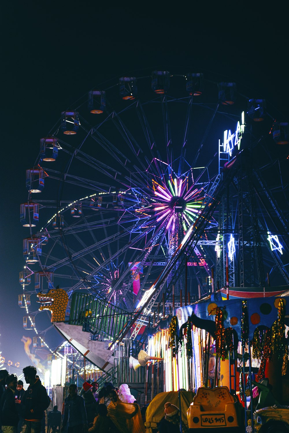 a carnival with a ferris wheel at night