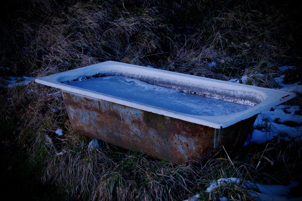 a bathtub sitting in the middle of a field covered in snow