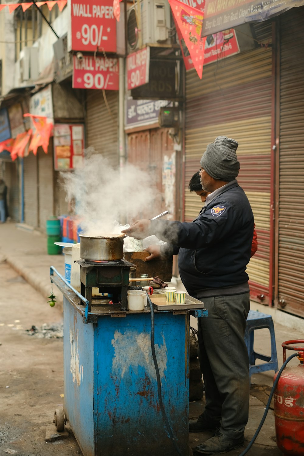 a man cooking food on top of a blue grill