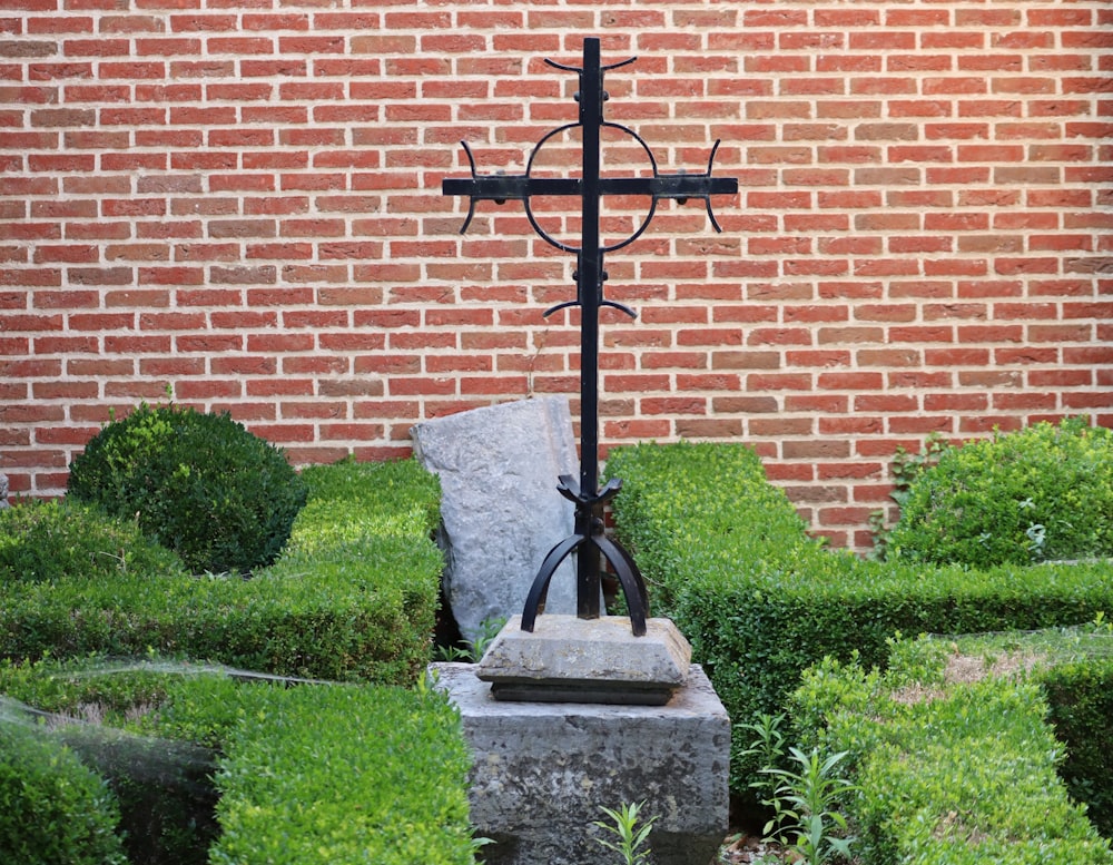 a cross on top of a rock in a garden