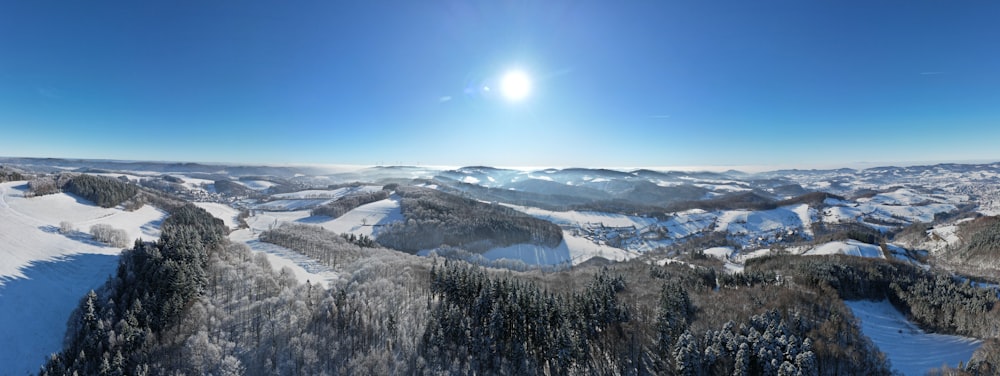 the sun is shining over a snowy mountain range