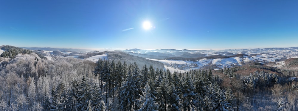 the sun is shining over a snowy mountain range