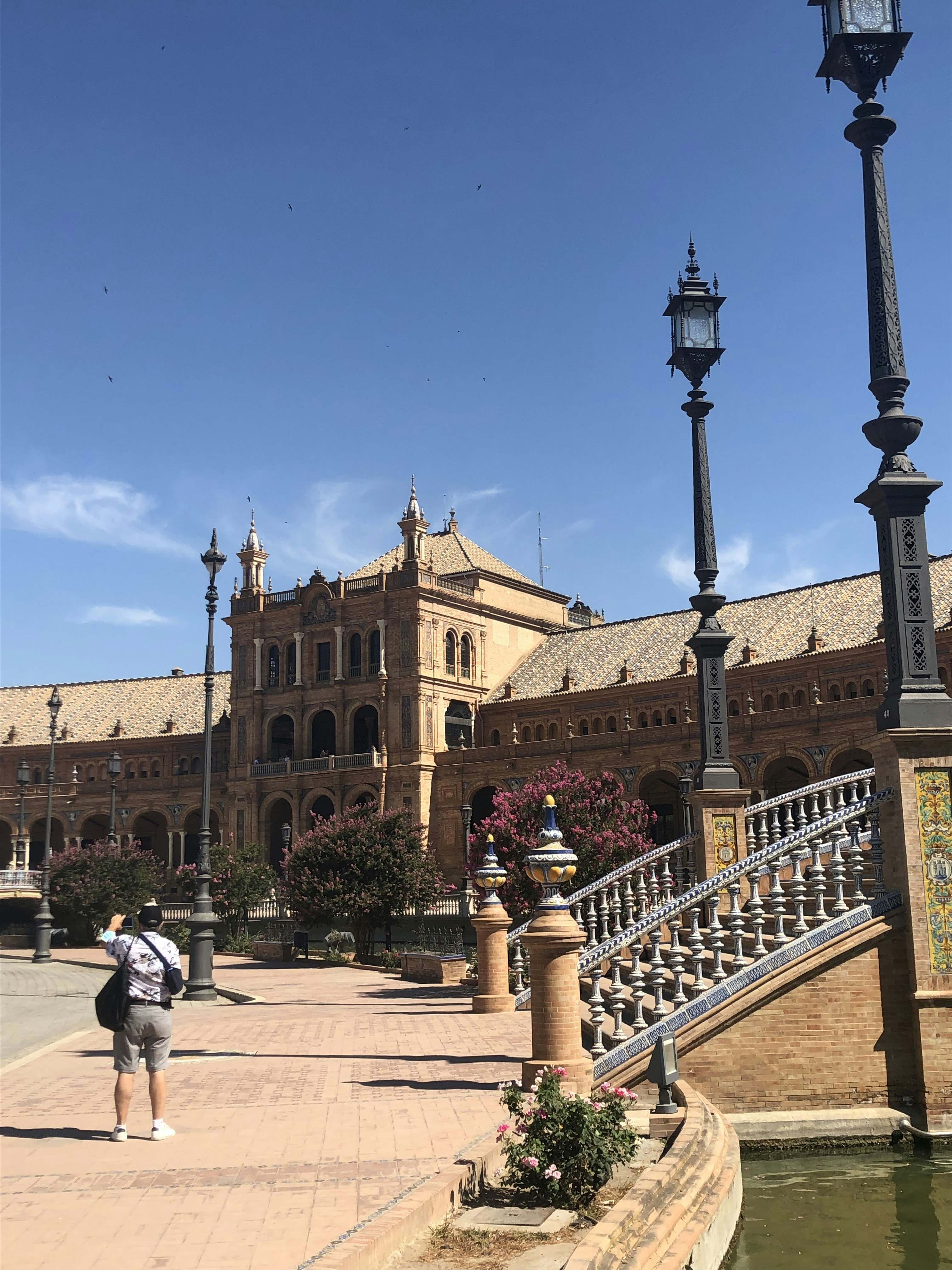 un uomo che cammina lungo un marciapiede accanto a un edificio alto
