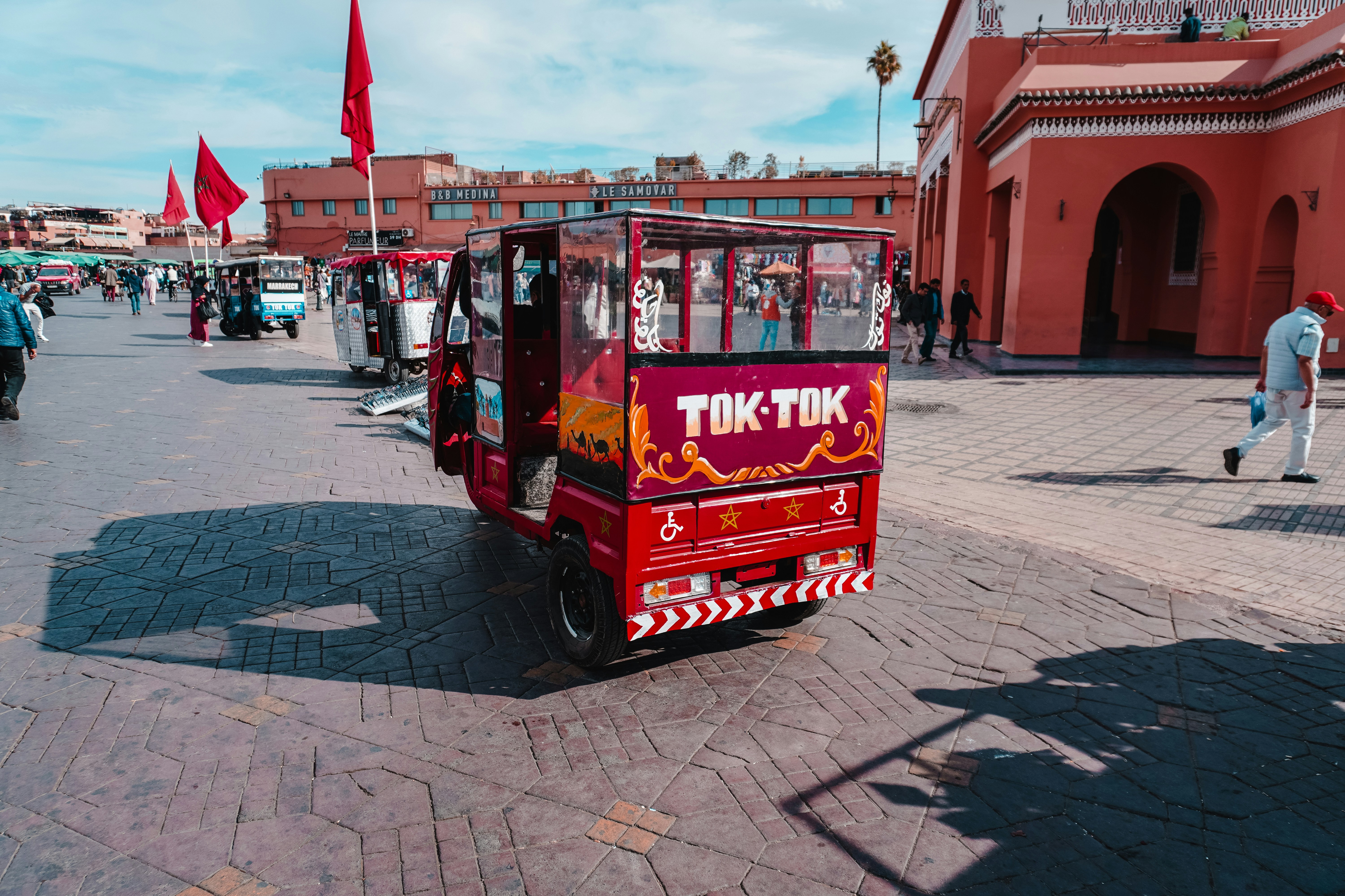 A small red car parked in front of a building