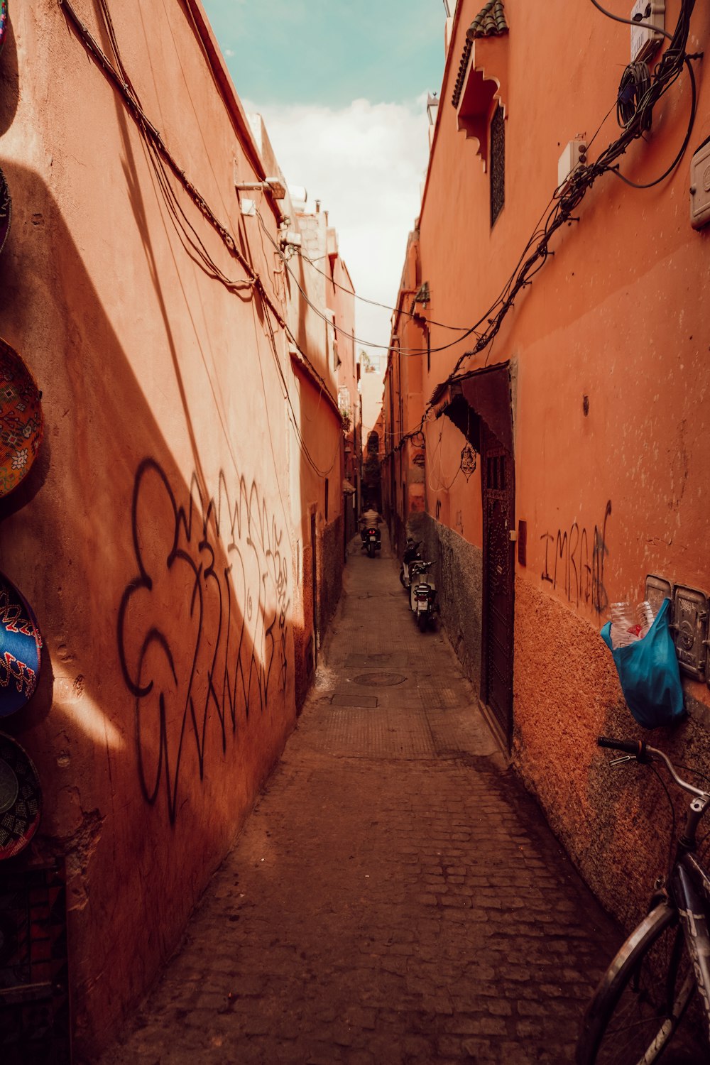 a narrow alley with graffiti on the walls