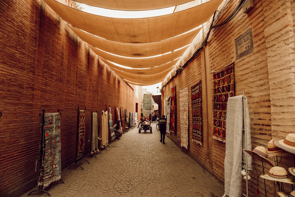 a narrow alley with a few people walking down it