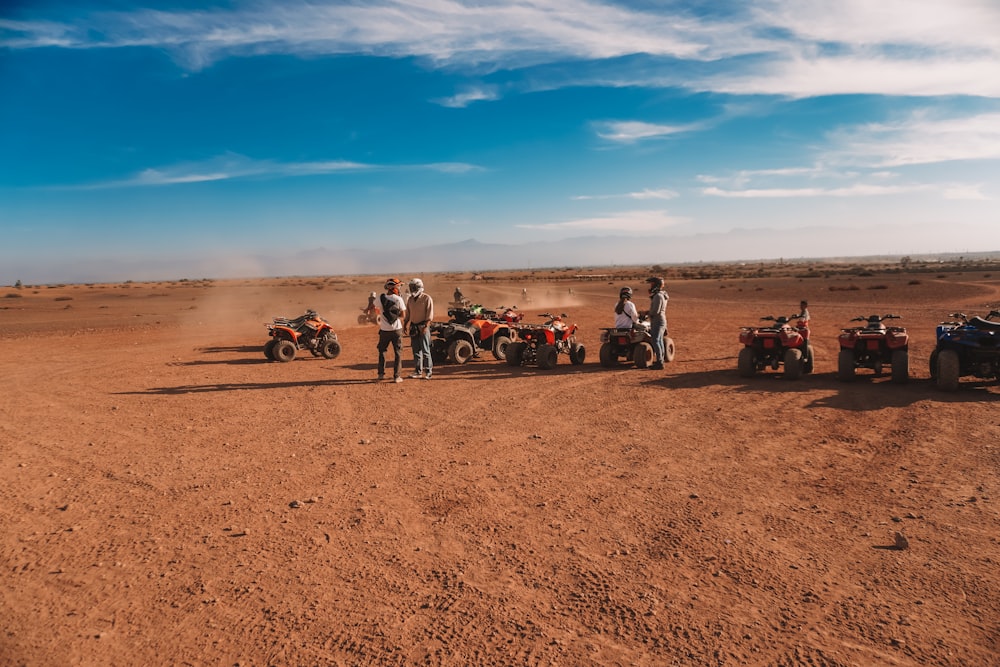 a group of people on four wheelers in the desert