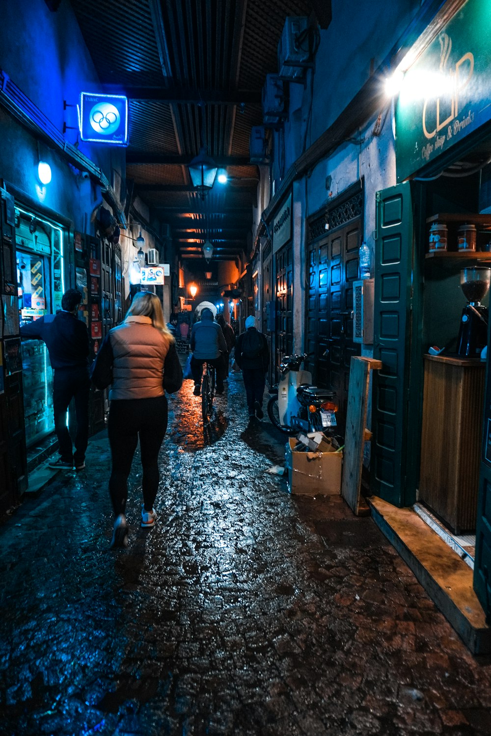 a group of people walking down a street at night