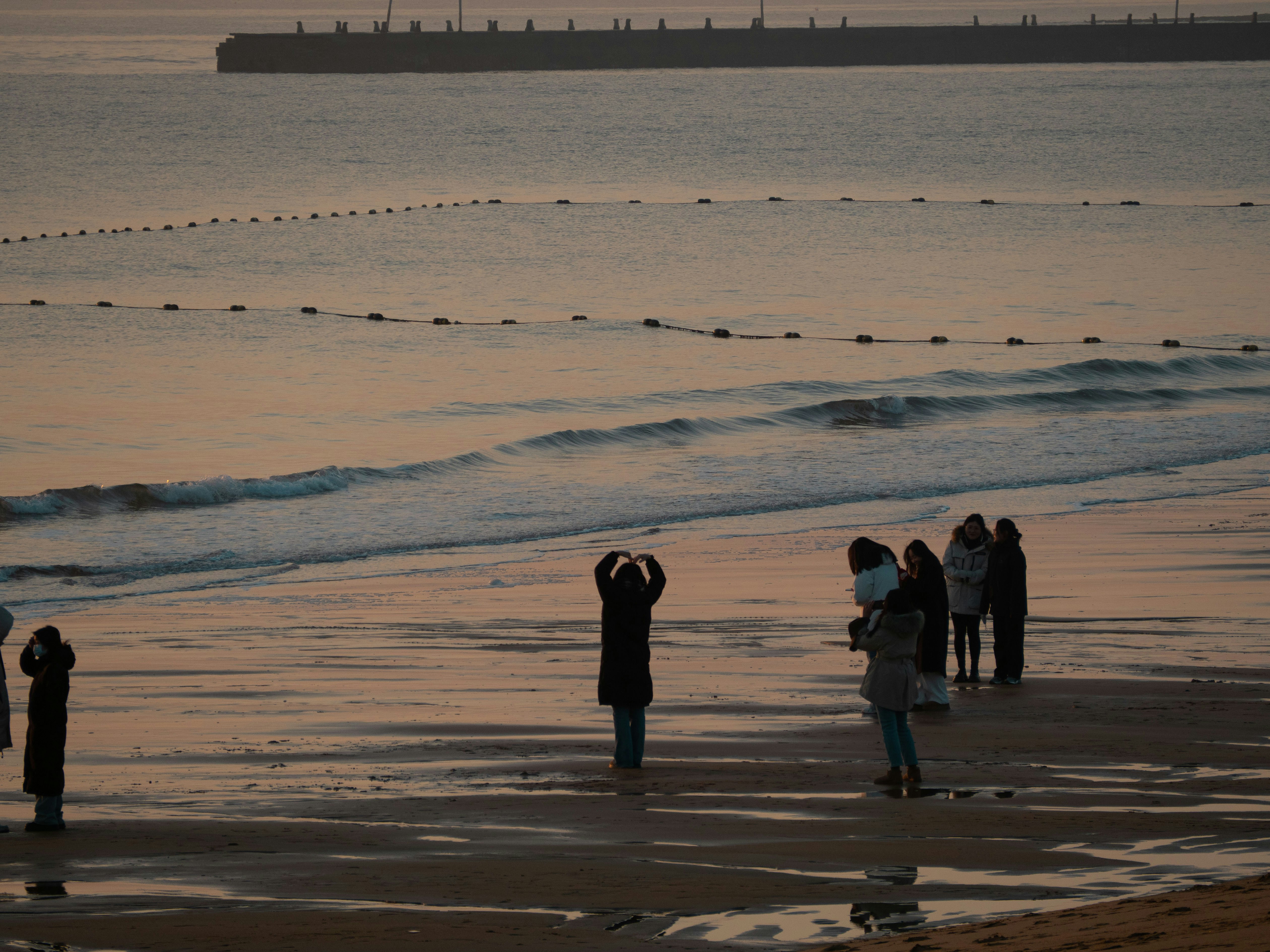 a group of people standing on top of a beach