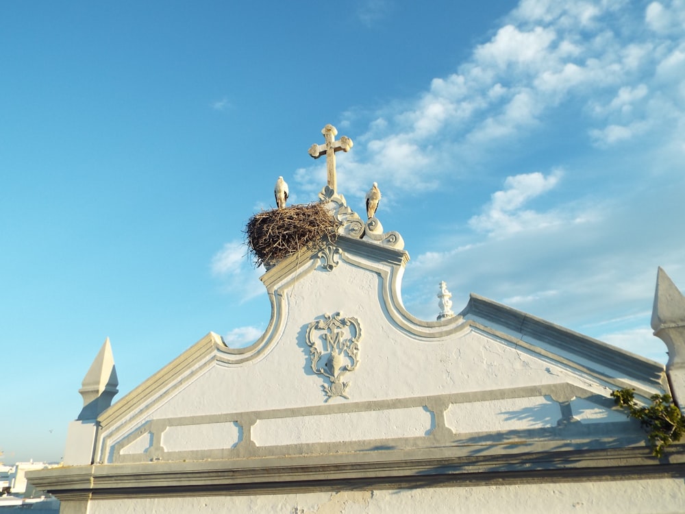 a white building with a bird nest on top of it