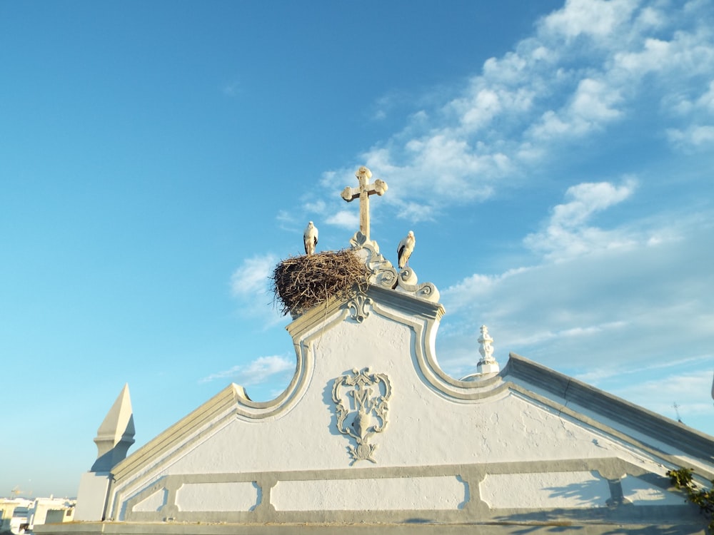 a white building with a bird nest on top of it