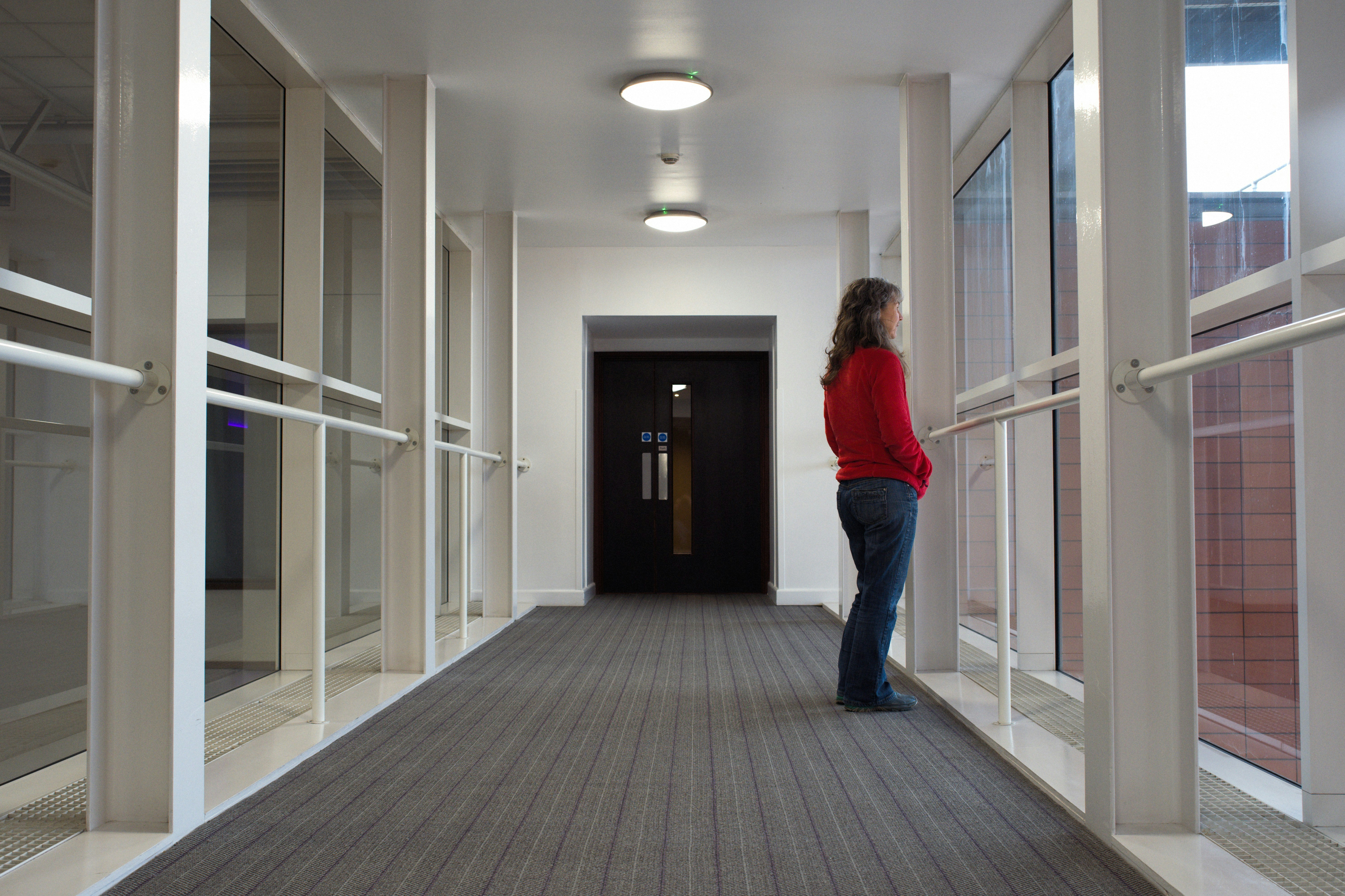 Woman standing in the hallway and gazing out of the windows