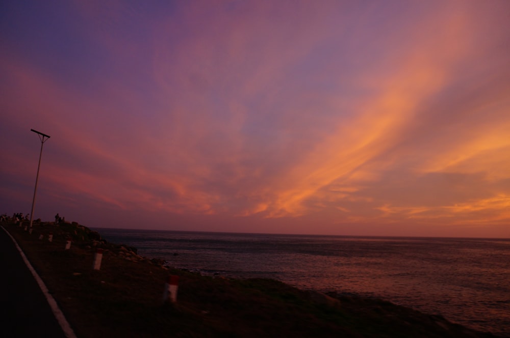 a sunset over a body of water with clouds in the sky