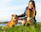 a woman kneeling down next to a brown dog