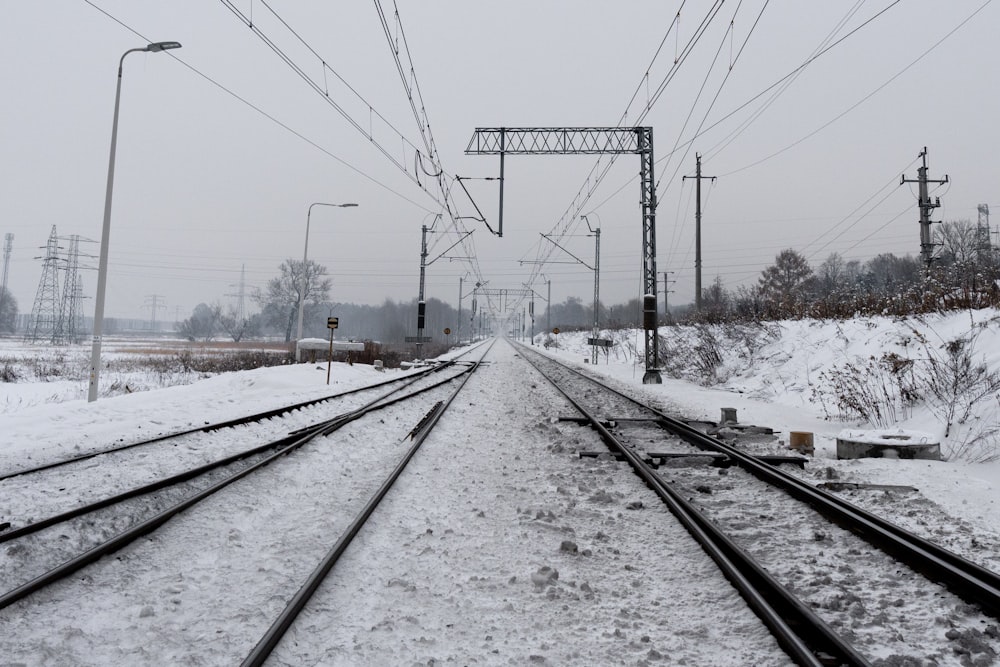 une voie ferrée avec de la neige au sol