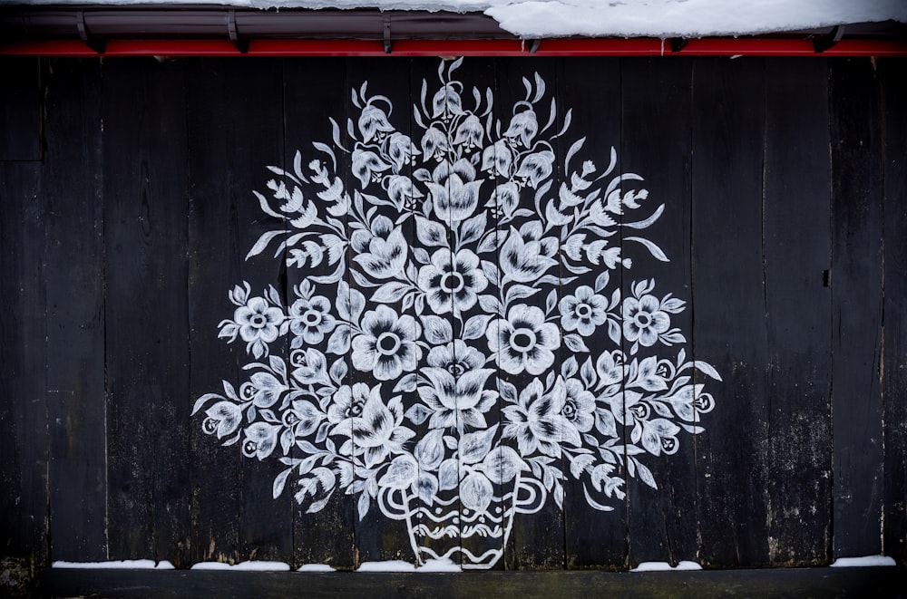 a painting of a flower arrangement on a wooden wall