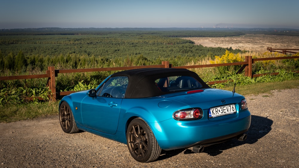 a blue sports car parked on the side of a road