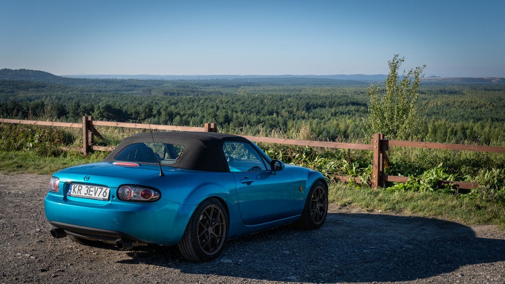 a blue sports car parked on the side of a road