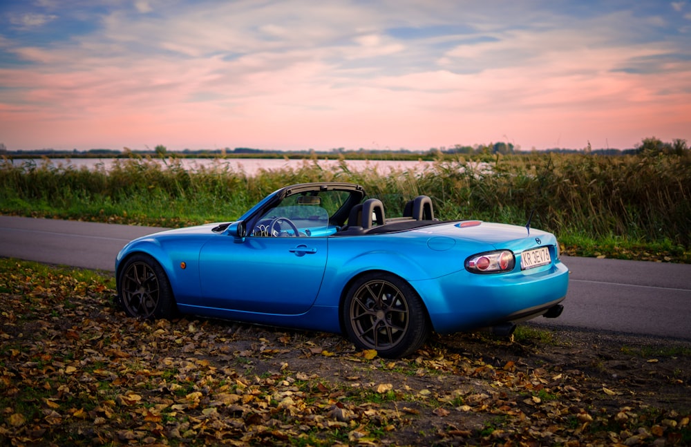 a blue sports car parked on the side of the road