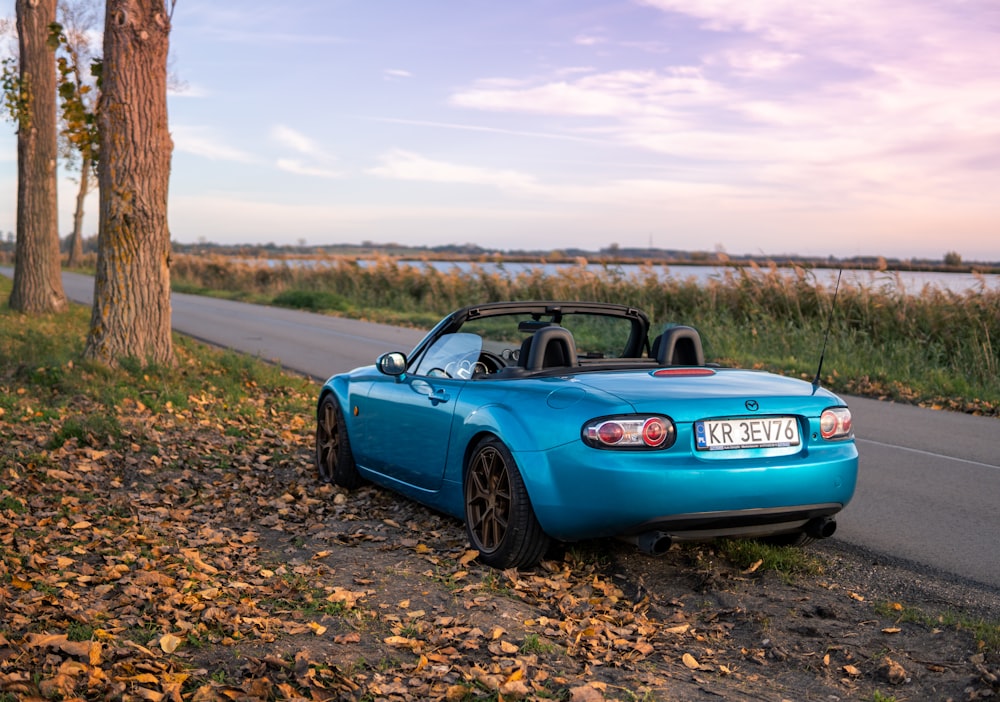 a blue sports car parked on the side of the road