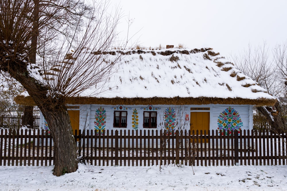 a house with a thatched roof covered in snow