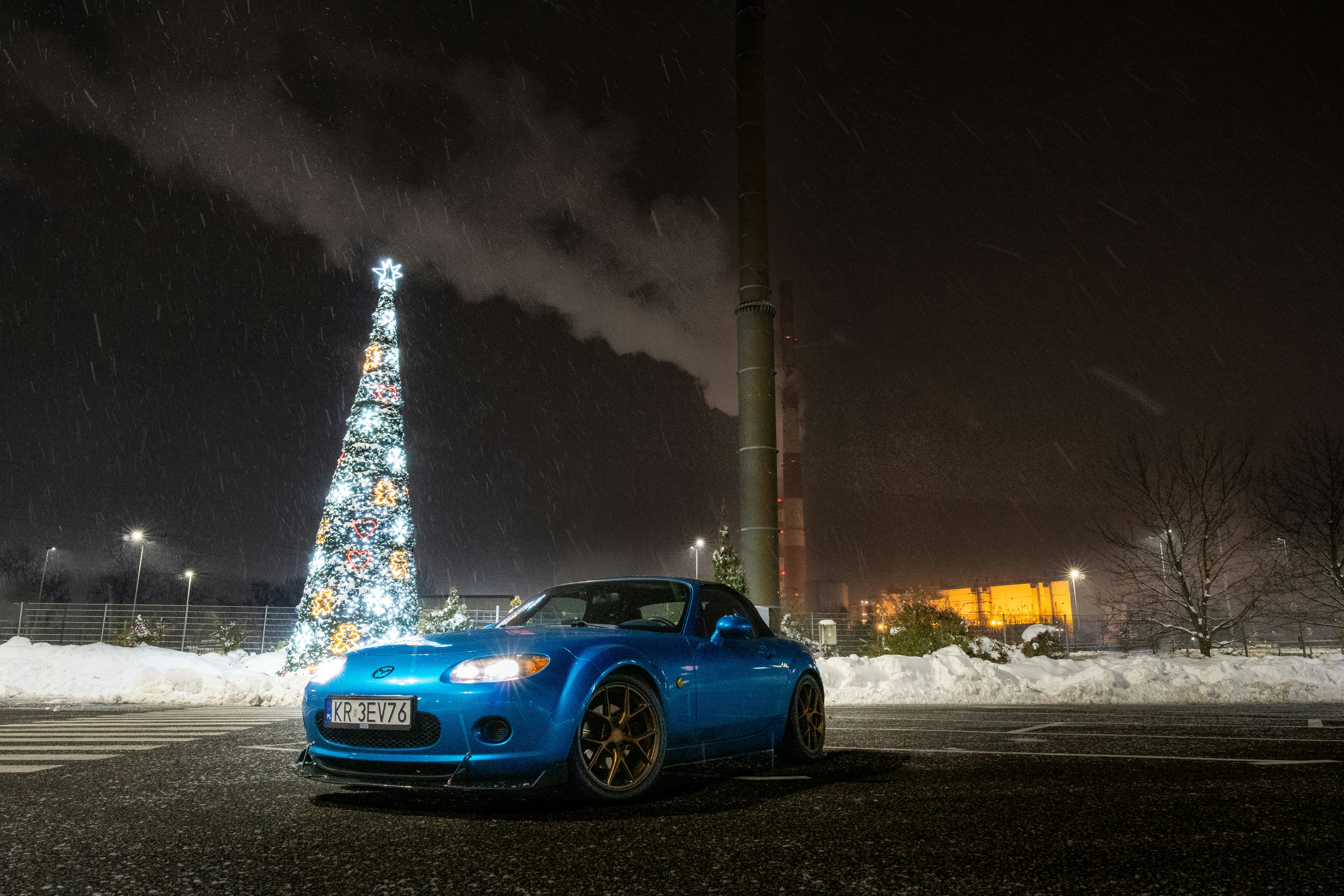 クリスマスツリーの前に停められた青いスポーツカー