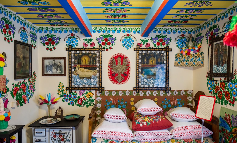 a room with a bed covered in lots of pillows