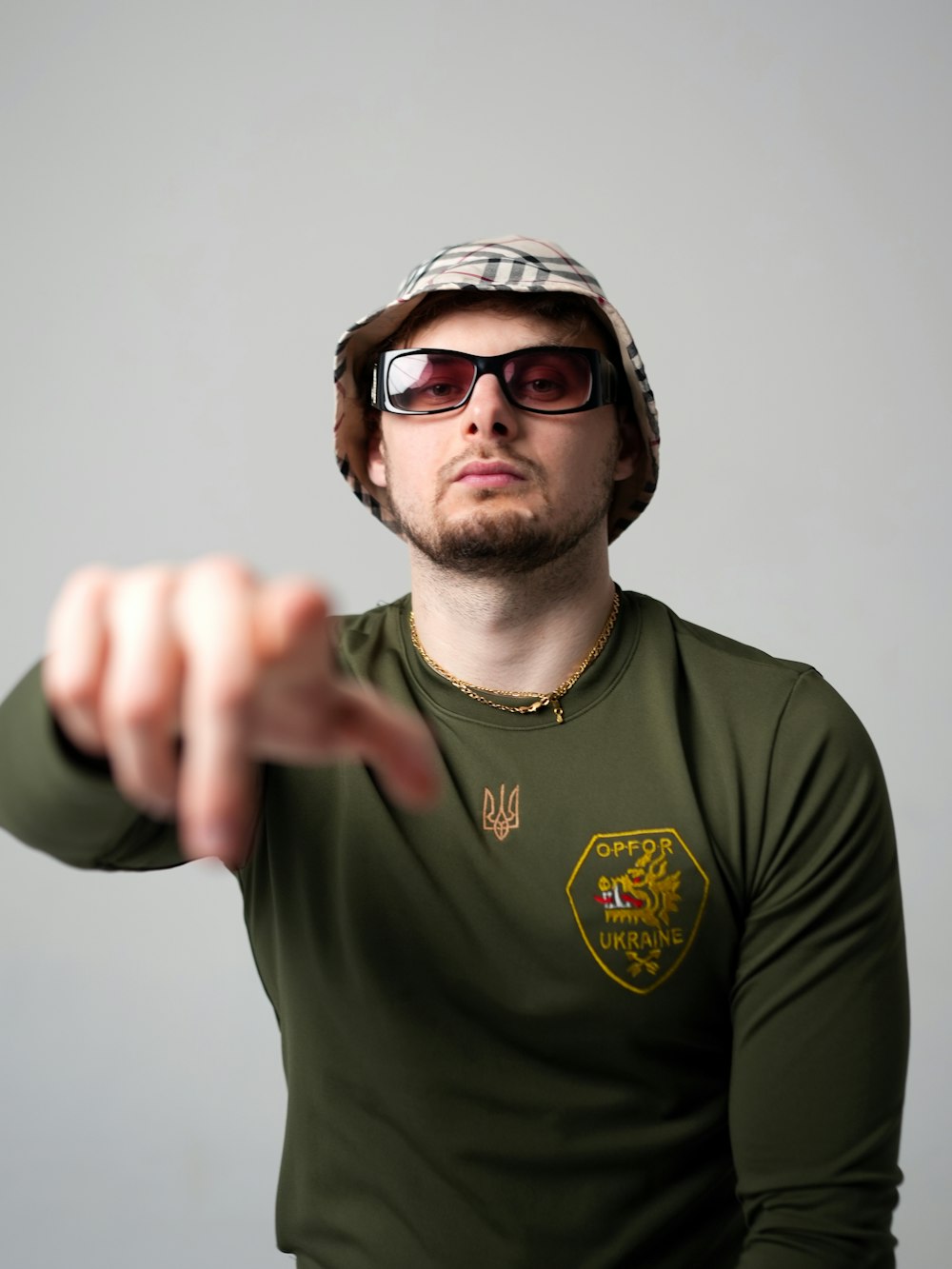 a man in a green shirt pointing at something