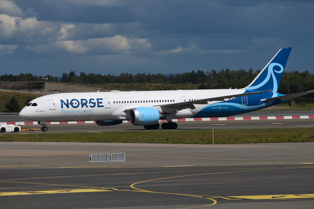 a large white and blue airplane on a runway