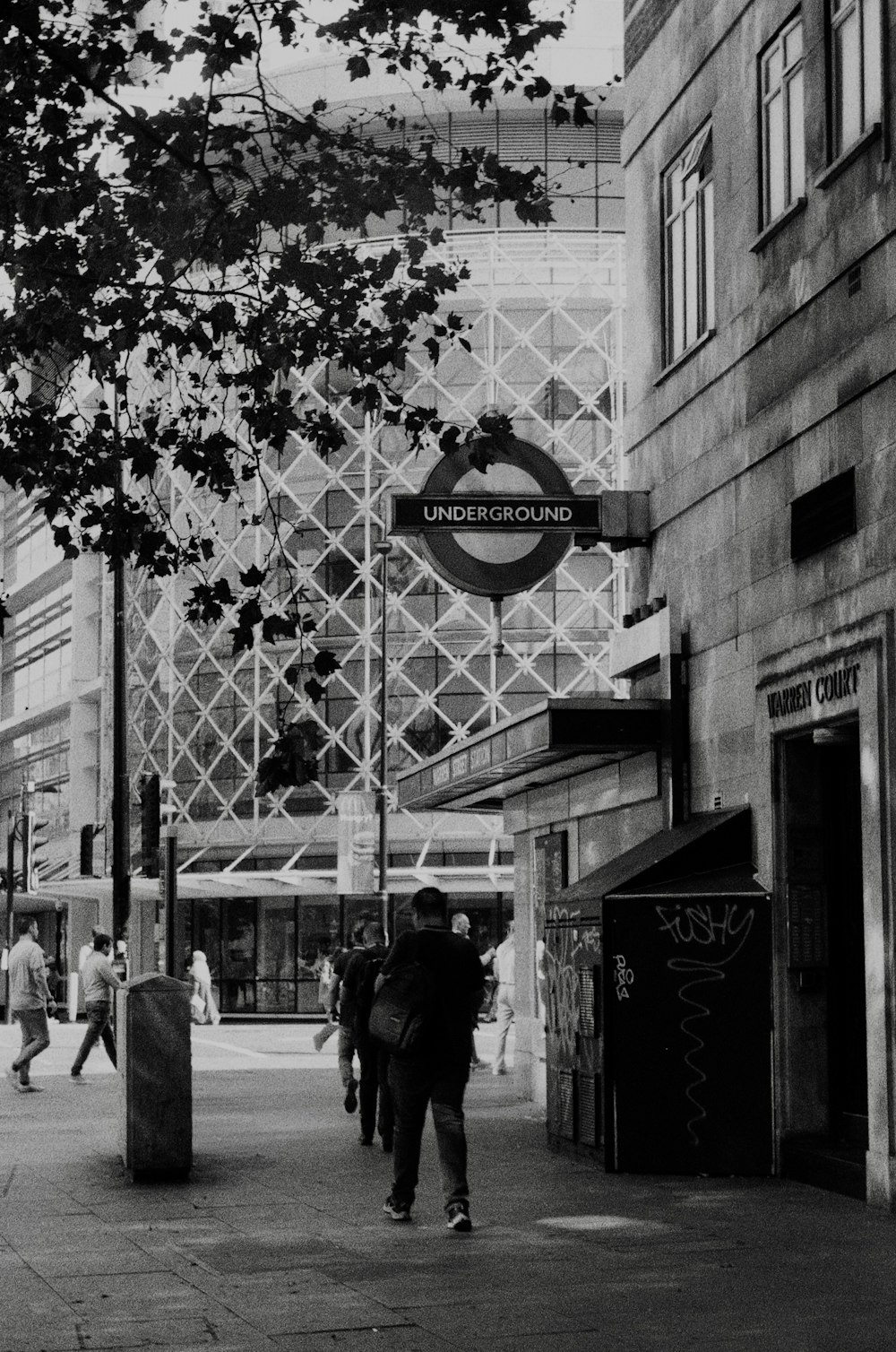 a black and white photo of people walking down a street