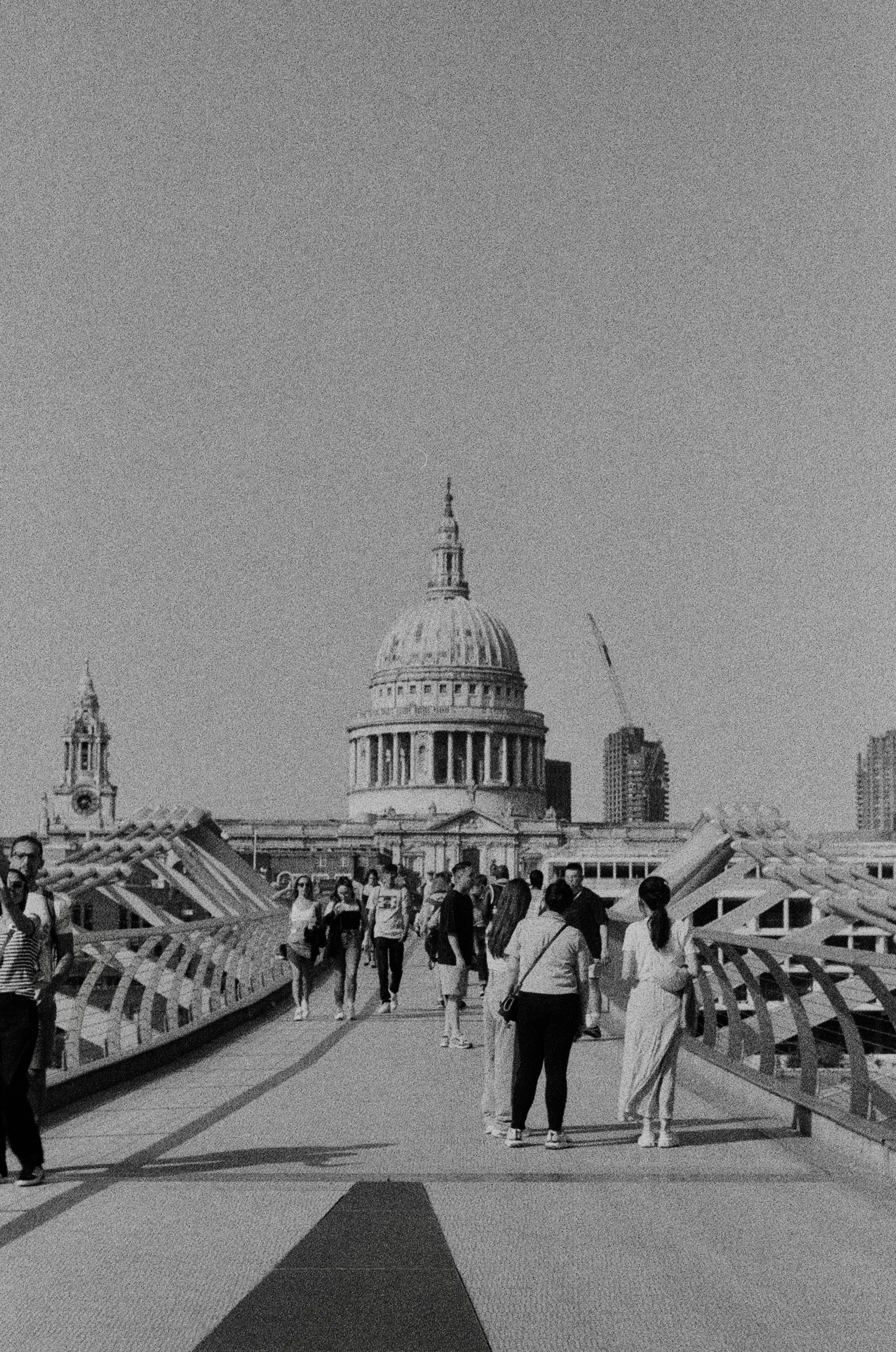 a group of people walking across a bridge