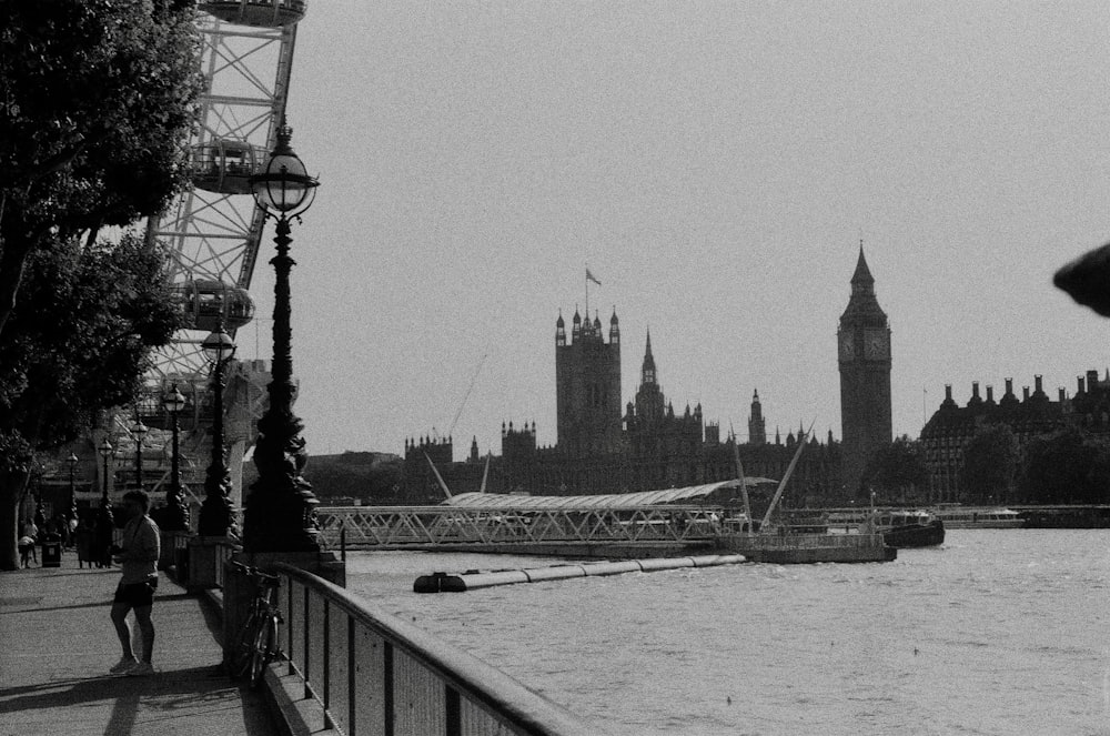 a black and white photo of a river and a bridge