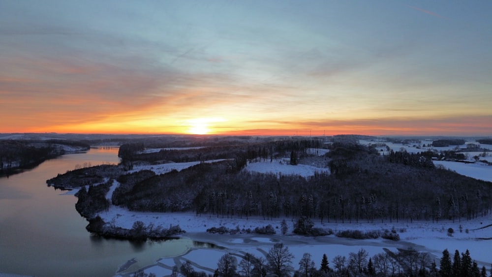 the sun is setting over a snowy landscape