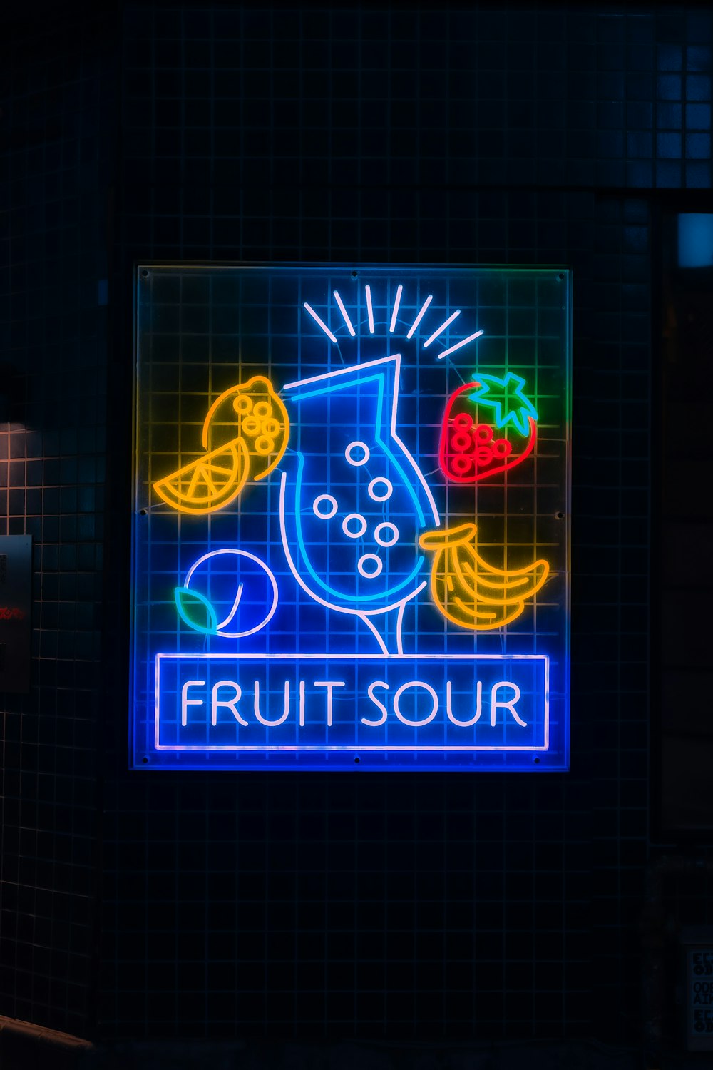a neon sign that says fruit sour on it