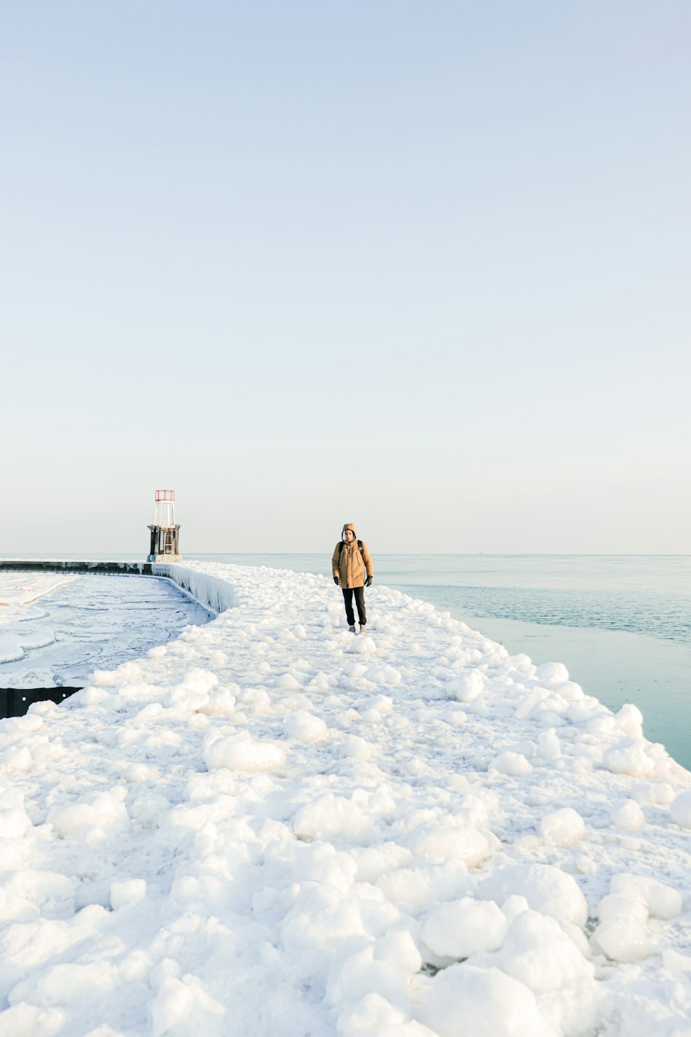a person standing on a pier covered in snow