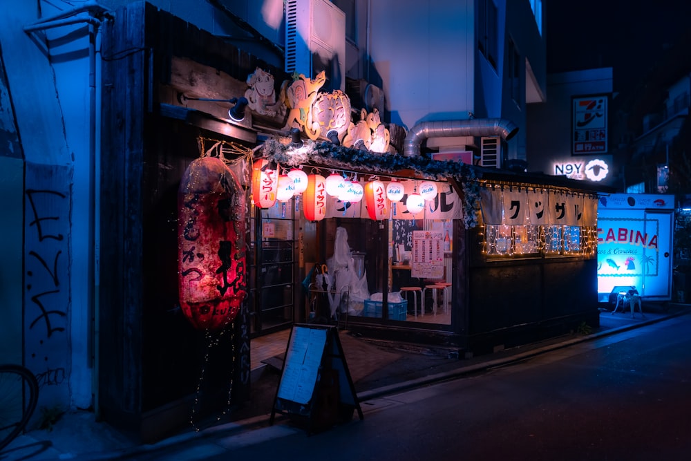 a dark street with a store front covered in lights