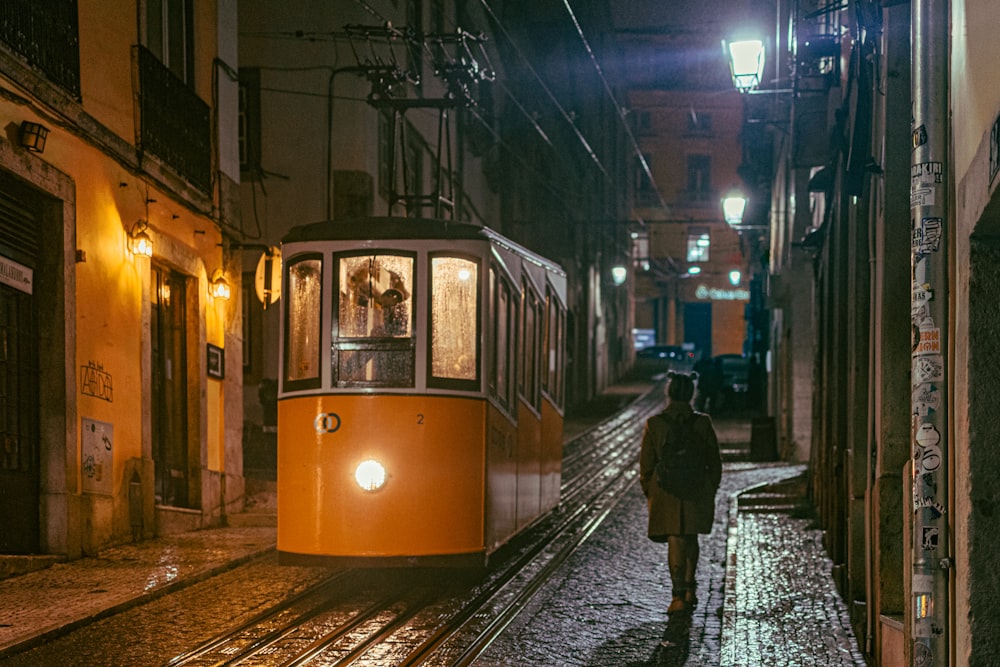 a person walking down a street next to a trolley